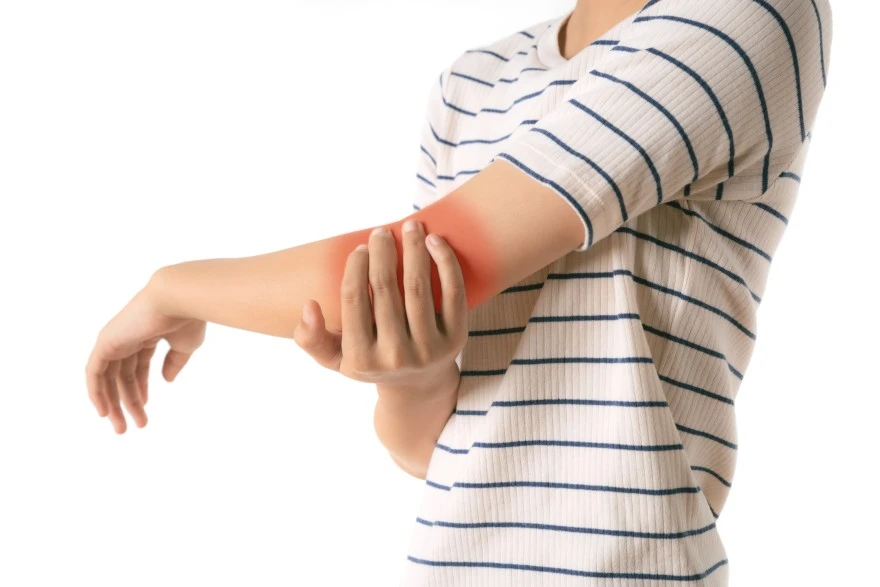 person holding arm in discomfort due to arm pain